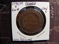 Front side of the coin showing 'UN DECIME L'AN 5' within a wreath, encased in a cardboard holder with handwritten label.