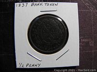 Obverse side of the 1837 Province of Canada Half Penny Bank Token showing shield and wreath design with inscription.