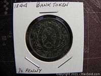 Obverse side of the 1844 Province of Canada half penny bank token showing shield with crossed flags and inscriptions