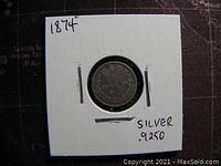 Reverse side of the 1874 Great Britain 3 pence coin showing the denomination and date inside a cardboard holder with handwritten year and silver purity.
