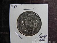 Reverse side of the 1951 Canadian 50 cent silver coin showing Canadian coat of arms and denomination.