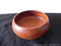 Angled side view showing shape and wood grain of the teak bowl