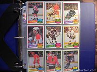 Photo of hockey trading cards from Flyers, Maple Leafs, Canucks, Capitals, Jets, Bruins, Flames, and Black Hawks teams inside a binder sleeve.