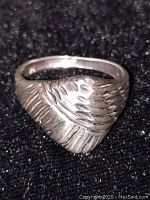 Close-up photo of the chunky 925 sterling silver ring showing detailed textured feather-like pattern.
