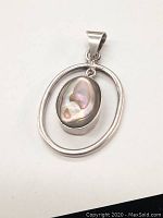 Image of pendant with abalone shell centerpiece on white background