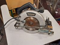 Side view of Mastercraft circular skill saw showing rusted blade, black handle, and attached power cord with electrical tape.