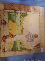 Photo of the Elton John Yellow Brick Road vinyl record album showing the illustrated cover art with Elton John walking on a yellow brick road.