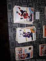 Photo showing several stacks of O-Pee-Chee hockey cards including a visible card of Bobby Clarke of the Philadelphia Flyers, and Chris Dwyer of the New York Islanders.