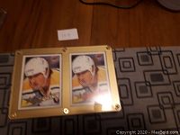View showing two Mario Lemieux hockey cards side by side within a gold screwback case with visible screws at corners and edges.