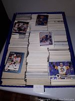Large box filled with multiple stacks of hockey cards, showing variety of player images and teams from the 1990s era.