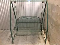 Full front view of the green metal garden swing.