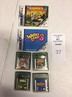 Photo showing four Game Boy Color game cartridges and two instruction booklets on a white surface.