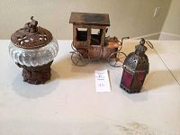 Photo of the lot items including the pedestal bowl with decorative lid, copper animated car, and brass lantern.