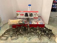 Photo of assorted metal cookie cutters lying on surface with boxed Star Wars cookie cutter set in background