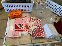Full view of assorted holiday napkins, candy boxes, orange silicone mold, and glass pedestal platter.