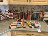 Photo showing assorted books on countertop, includes Encyclopedia of Women of the United States, Happened in America, biographies of presidents, fiction and other titles