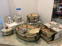 Overall view of set including four ceramic bakers, metal stands, 3 plastic lids, and utensils