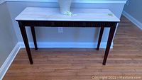 Front view of wood console table with marble top