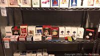 Shelf displaying multiple Hallmark Keepsake ornaments in original boxes including Dunkin Donuts, Mickey Mouse, Football Legends.