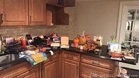 Kitchen countertop with assorted Halloween and autumn decoration items including pumpkin decor, napkins, and boxed items.