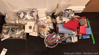 Overview of assorted jewelry items in boxes and containers including bracelets, hair accessories and keepsake boxes.
