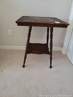 Full view of vintage solid wood side table with square top, turned spindle legs, and lower shelf. Shows wear and needs refinishing.