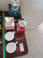 View of mugs, tea cup, candy dish, and mug warmer arranged on table
