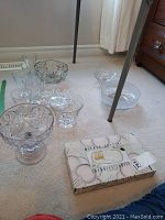 Mikasa crystal glassware set with bowls, sandwich tray, and drink ware on carpeted floor under table.