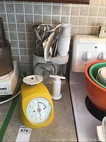 Photo of Bamix immersion blender with attachments and yellow kitchen scale on kitchen counter.