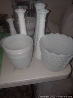 Group of milk glass vases showing hobnail pattern and scalloped rims