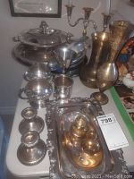Image showing assorted silver plate items including trays, servers, creamer, sugar set, and a pair of 3-branch candlesticks.