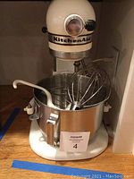 Front view of mixer with bowl and attachments inside