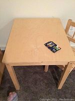 Wooden children's table top showing smooth surface and minor wear.