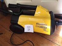 Yellow and black Eureka The Boss vacuum cleaner showing side view, label visible