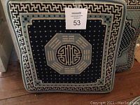 Front view of one large square needlepoint pillow showing detailed blue and white geometric pattern with central medallion.