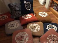 Set of Asian themed cushions and pillows arranged on the floor showing variety of colors and fish motifs on square cushions with butterfly and floral pillows visible behind