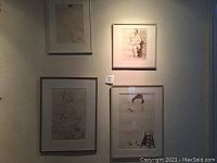 Four framed sketches of women hung on a wall, showing varying sizes and frames.