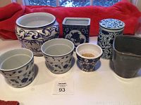 Full set of seven pottery planters on a counter with a red towel background
