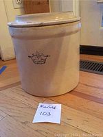 Front view of the off-white stoneware pot with a crown emblem and number 2.