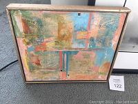 Abstract mixed media artwork with acrylic paint and newspaper collage, framed