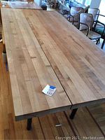 Photo of butcher block table top showing wood strips, natural wood finish with markings, stains, and a gap between boards.