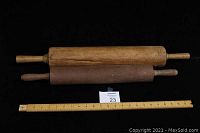 Two vintage wooden rolling pins side by side with a ruler below for scale. One pin is 23 inches, the other 28 inches with a dent in the barrel.