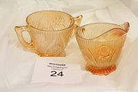 Two amber iridescent glass pieces with floral pattern, cup and creamer view