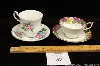 Two Paragon fine bone china teacups and saucers side by side with measuring ruler below