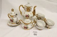 Full tea set arranged including teapot, sugar bowl, creamer, six teacups and saucers showing floral and gold trim details