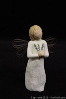 Single Willow Tree figurine with wire wings holding sprigs, light colored carved resin figure