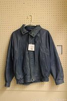 Full front view of the indigo leather jacket hanging on a hanger showing overall condition and fit.