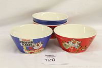 Front view of four Kellogg's themed cereal bowls showing two blue Frosted Flakes bowls and two red Hold that tiger bowls, all featuring Tony the Tiger graphics and logos.