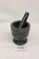 Front side view of the dark grey marble mortar and pestle set. Mortar shows smooth interior surface with minimal wear.
