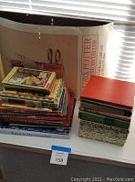Stack of 21 children's books of various titles and a rolled Harry Potter poster behind them